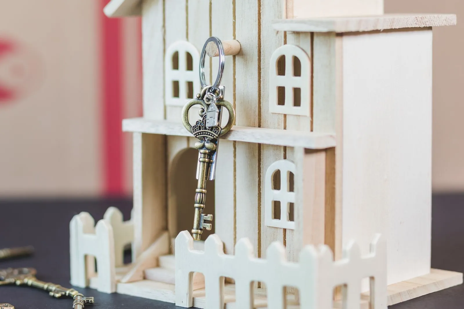 Llave colgada de una casa de madera en miniatura